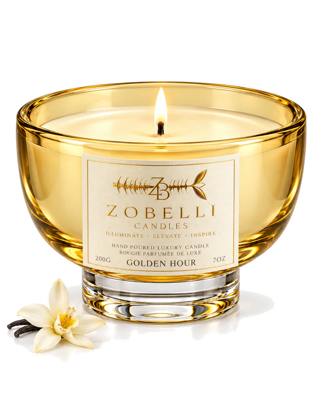 Golden Hour Zobelli candle in golden pedestal glass with a printed gold paper label on a white studio background